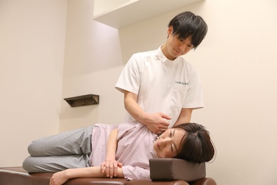 草加鍼灸院 整骨院で女性の方をせ術している画像
